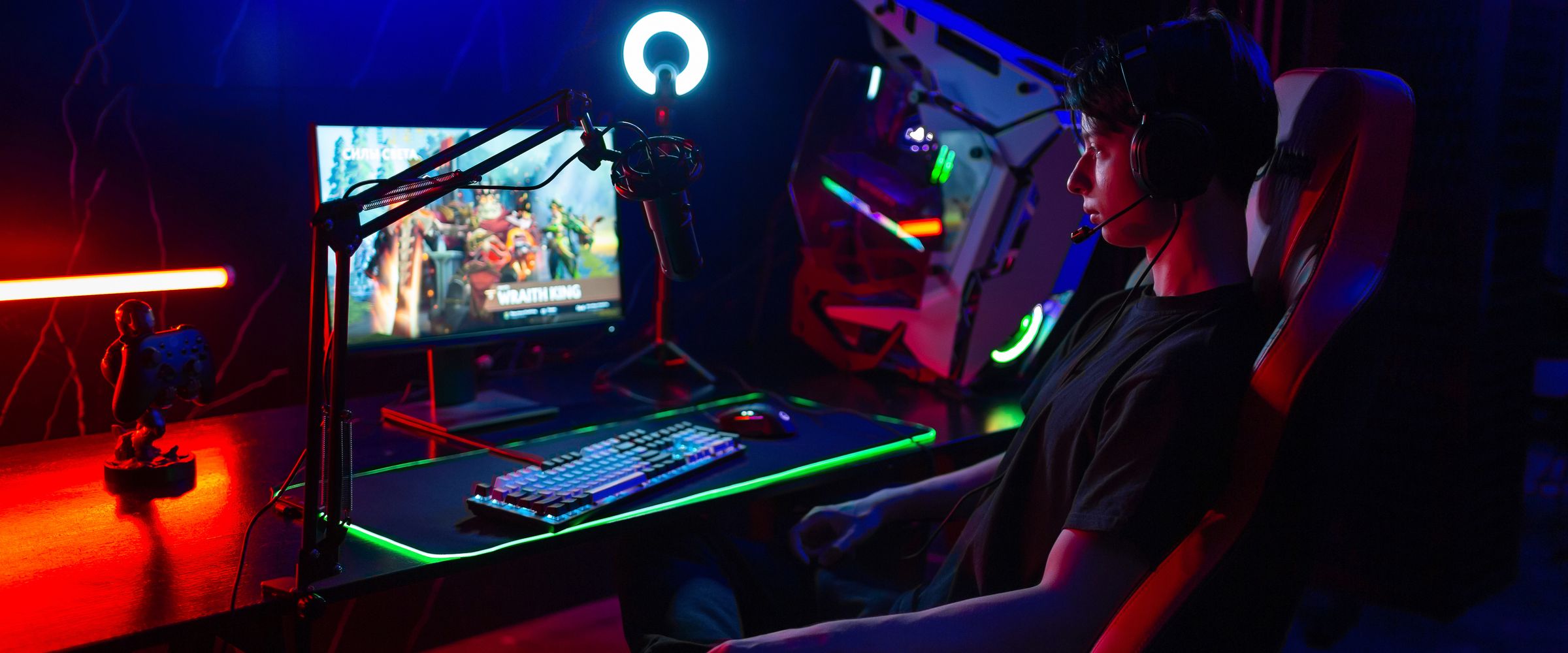 Gracz przy stanowisku LORGAR w kolorowym świetle — monitor, podświetlana klawiatura i podkładka RGB